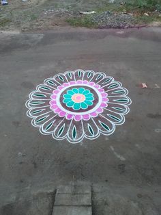 a colorful flower design is painted on the ground