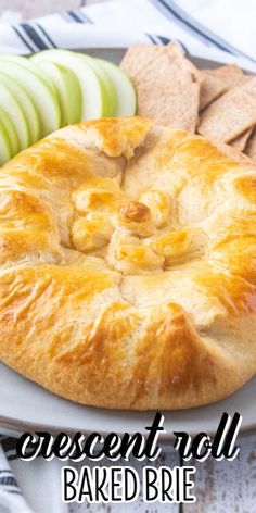 a close up of a pie on a plate with crackers and apples in the background