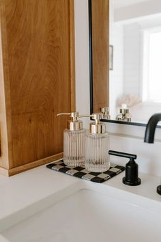 a bathroom sink with two soap dispensers on it