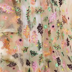 the sheer fabric has colorful flowers on it