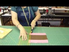 a woman cutting fabric with scissors on a table