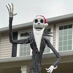 an inflatable skeleton wearing a santa hat and striped suit