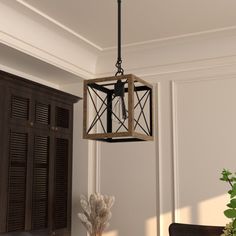 a light fixture hanging from the ceiling in a room with white walls and wooden furniture