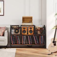 a living room with two couches, a book shelf and a guitar on the floor