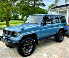 a blue suv parked in front of a house