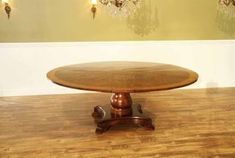 a wooden table sitting on top of a hard wood floor next to a chandelier