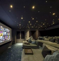 a home theater with two couches and a projector screen in the middle of the room