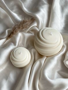 two candles sitting on top of a white cloth