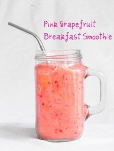 a pink grapefruit breakfast smoothie in a mason jar with a straw sticking out of it