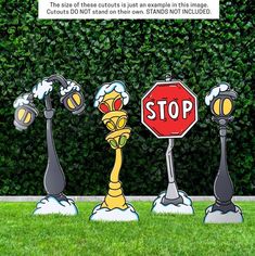 three street lamps and a stop sign in front of a hedge