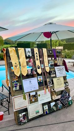 a display with ties and pictures on it near a swimming pool at sunset or dawn