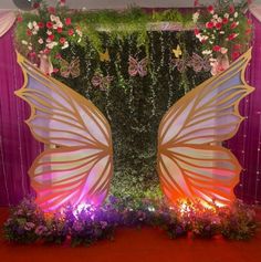 an elaborate butterfly backdrop with flowers and greenery for a wedding or special event venue