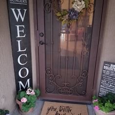 a welcome mat sits in front of a door with potted plants on the doorstep