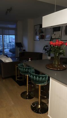 a living room filled with furniture next to a kitchen and dining room table in front of a large window