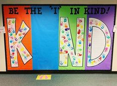 colorful bulletin board with handprints and the words be the it in kind on it