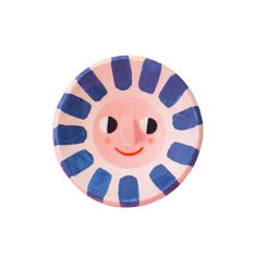 a blue and pink plate with a smiling face on it's side, against a white background