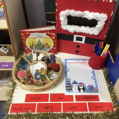 a christmas display with santa's helper and other items on the table in front of it