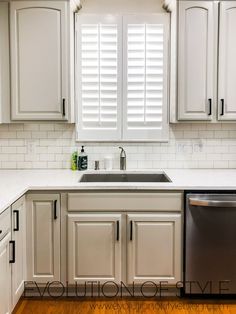 a clean kitchen with white cabinets and wood flooring, including a dishwasher