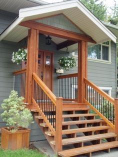 a porch with stairs leading up to the front door and side entry area, along with potted plants on either side