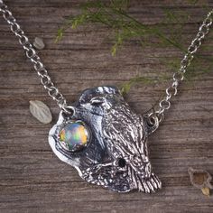 "Raven pendant with opal gemstone with a sterling silver necklace. Measurments and details: This pendant is sculptured by hand in wax and cast in sterling silver. ⭐️ Size and details: Pendant Hight: 1\" (5 cm) Pendant Width: 0.9\" (2 cm) ⭐️ Genuine opal gemstone in 5 mm. ⭐️ Sterling silver chain length to choose your preferred length. All my jewelry are handmade by me and inspired from my love to nature, ancient cultures and my practice in energy world. My designs are pack in a jewelry gift box Artisan Silver Opal Necklace, Unique Ethiopian Opal Necklace Gift, Silver Ethiopian Opal Pendant Jewelry, Silver Ethiopian Opal Pendant Necklace, Handmade Ethiopian Opal Silver Necklace, Handmade Silver Necklace With Ethiopian Opal, Crow Pendant, Silver Bird Necklace, Raven Jewelry