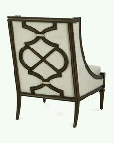 an ornate chair with white upholstered fabric and wood trimmings on the back