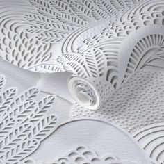 white paper with intricate designs on it and a rolled up piece of paper in the middle