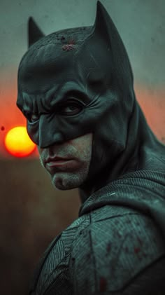 the dark knight batman is shown in front of an orange light with his head turned to look like he's about to go into action