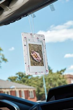 a photo hanging from the windshield of a car