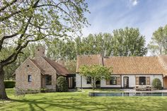 a house with a pool in front of it and lots of trees around the yard