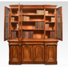 an old wooden bookcase with many books on the top and bottom shelves in front