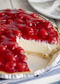 a cheesecake with cherries on top sits on a plate