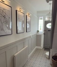 a hallway with pictures on the wall and a radiator in front of it