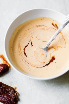 a white bowl filled with soup next to two dates