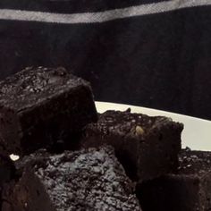 some brownies on a white plate with a black and white striped towel in the background