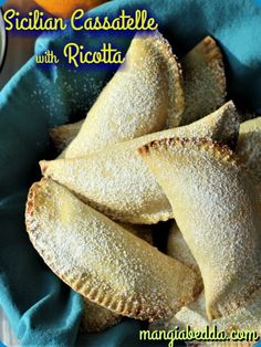 several pastries are in a blue bowl with powdered sugar on top and the words sicilian casserole with ricotta below