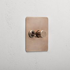 a light switch on a white wall with a black and silver knob in the middle