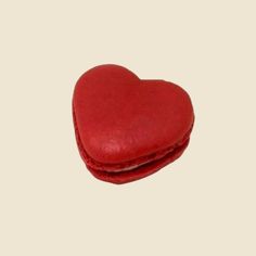 a red heart shaped pillow sitting on top of a table