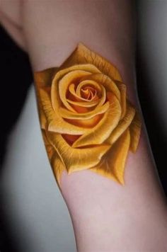 a yellow rose tattoo on the arm