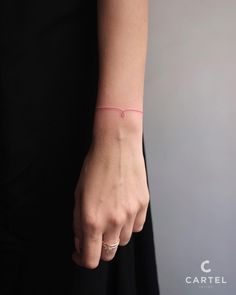 a woman's hand with a pink bracelet on her wrist