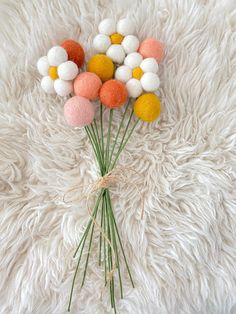 a bunch of flowers sitting on top of a fluffy white blanket with some green stems