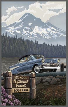 an old car parked on the side of a road next to a lake with mountains in the background