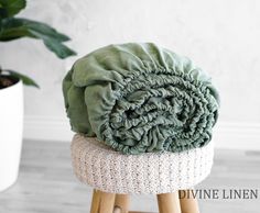 a blanket sitting on top of a stool next to a potted plant