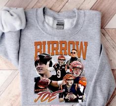 Stay stylishly warm in our Burrow Sweatshirt. Crafted from Gilden fabric, this one-of-a-kind shirt features Bengal's football. Perfect for cheering on the team, you'll be comfy and chic in this must-have wardrobe piece! Go ahead, show your team spirit! Winter Sporty Fan Merchandise Tops, Sporty Winter Fan Merchandise Tops, Casual Crew Tops For Football Season, Winter Team Spirit Graphic Print Tops, Team Spirit Graphic Print Winter Tops, Winter Sports Fan Top For Game Day, Long Sleeve Tops For Football Season, Sports Fan Tops For Game Day In Winter, Sporty Winter T-shirt For Fans