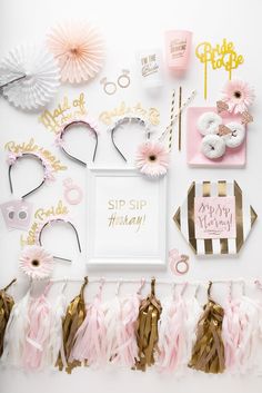 a white table topped with lots of pink and gold decorations