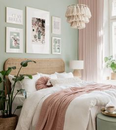 a bedroom with green walls and pictures on the wall above the bed, along with a wicker headboard