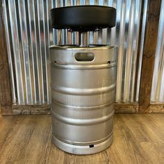 a metal barrel sitting on top of a wooden floor