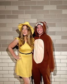 two people dressed up in costumes standing next to each other on a brick wall background