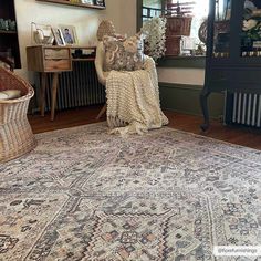 a large rug in the middle of a living room with an antique chair and other furniture