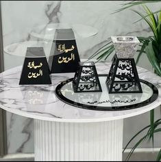 three black and white vases sitting on top of a marble table