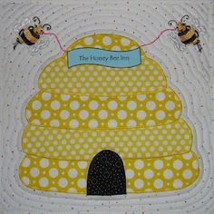 the honey bee inn quilt is yellow with white polka dots and two bees on it